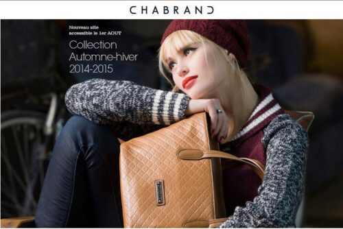 Mannequin élégant portant un bonnet bordeaux, veste grise et sac à main camel, mettant en valeur la collection automne-hiver 2014-2015 de Chabrand.