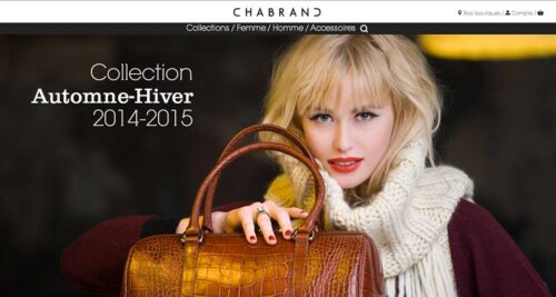 Mannequin posant élégamment avec un sac à main en cuir marron et un pull blanc, mettant en valeur la mode hivernale sophistiquée de la collection automne-hiver 2014-2015.