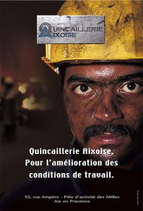 Mannequin portant un casque de chantier jaune et une tenue de travail, maquillage simulant de la saleté, style industriel mettant en avant la robustesse et la sécurité au travail.