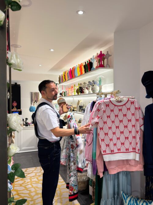 Installation scénographique d'une boutique moderne, décorée avec des vêtements colorés, mannequins stylisés et étagères lumineuses, créant une ambiance élégante et soignée dans l’espace de vente.